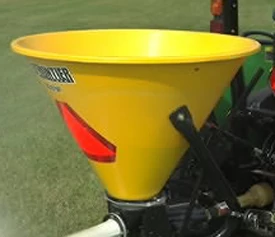 Close-up of a yellow SS1079P pendular spreader hopper with red hi-vis triangle pasted on its rear-facing side