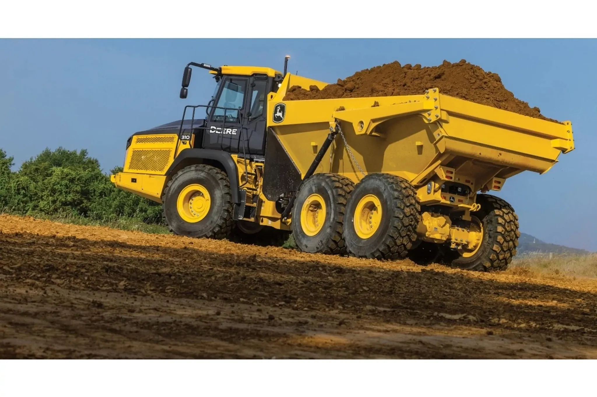 310 P-Tier ADT-Pulled Scraper Pan Scraper Systems with a loader truck with a load of dirt on the back