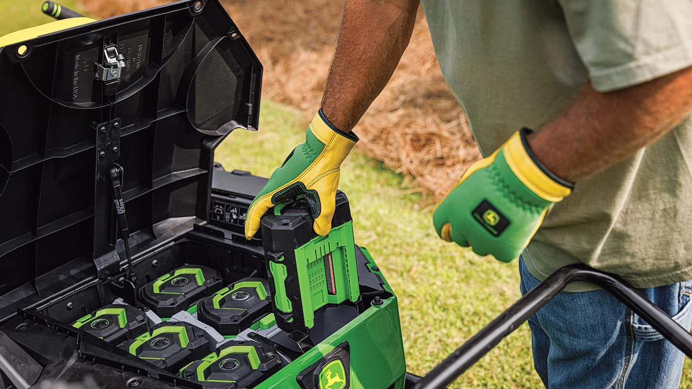 Operator holding one of six batteries from the new Z370RS Electric ZTrak Mower