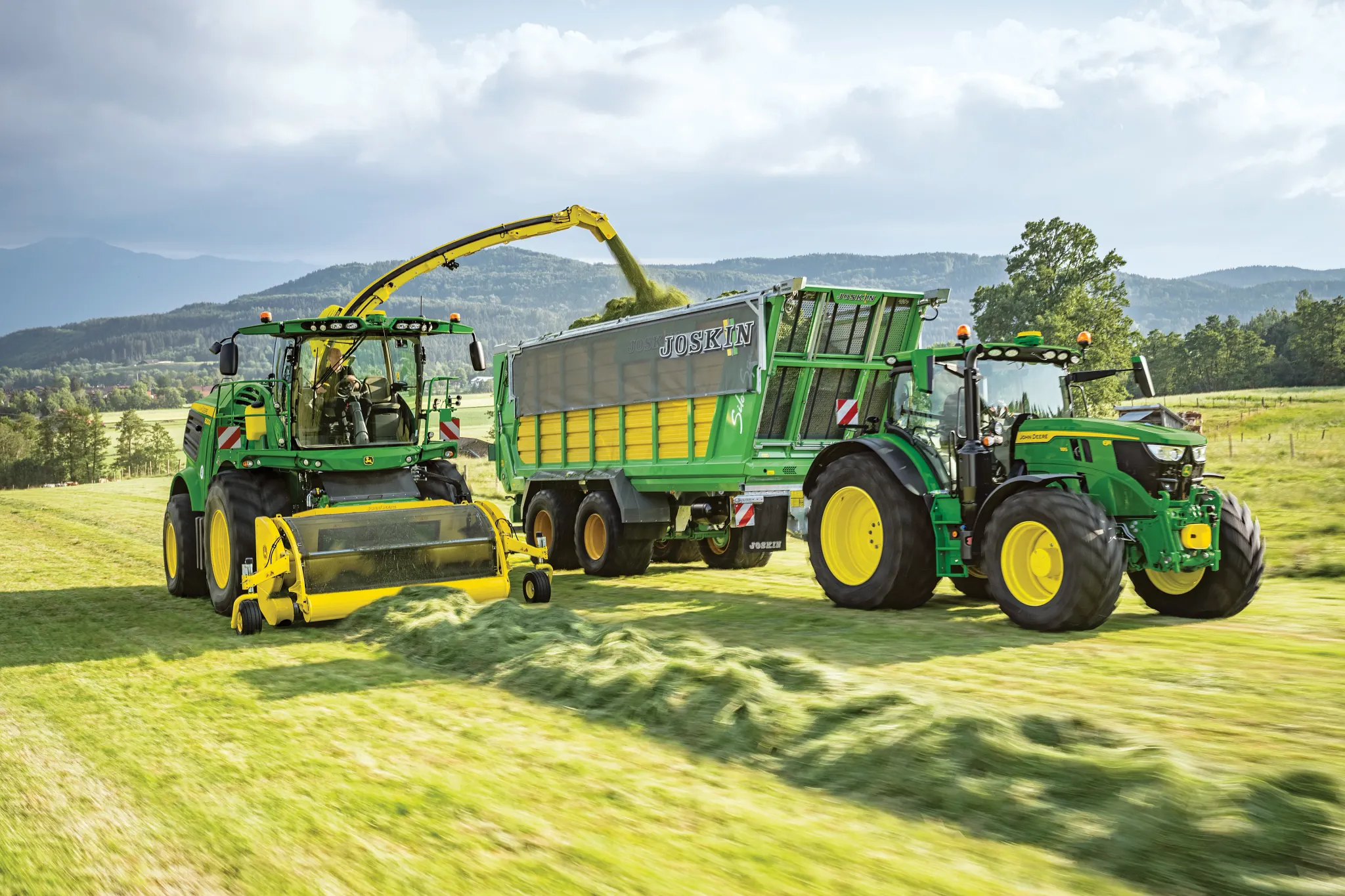 Self-propelled forage harvester filling wagon in the field