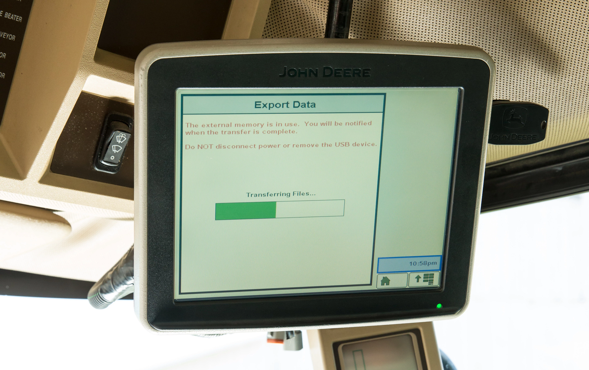 Close-up of a display inside a cab with Export Data screen showing. There is a green loading bar beneath "Transferring Files" text