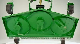 Underside of a green mower deck featuring three rotary blade housings, structural framing, and rear gauge wheels