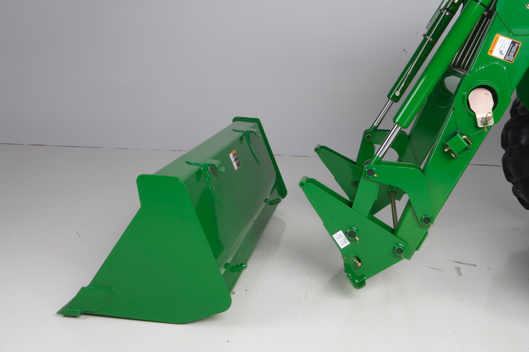 500E Front Loader arms positioned behind a detached bucket attachment resting on the ground