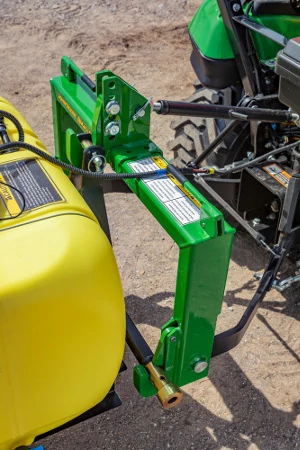 Top view of the green frame, yellow tank, and connection point between an LS liquid sprayer and tractor using iMatch™ Quick-Hitch compatibility