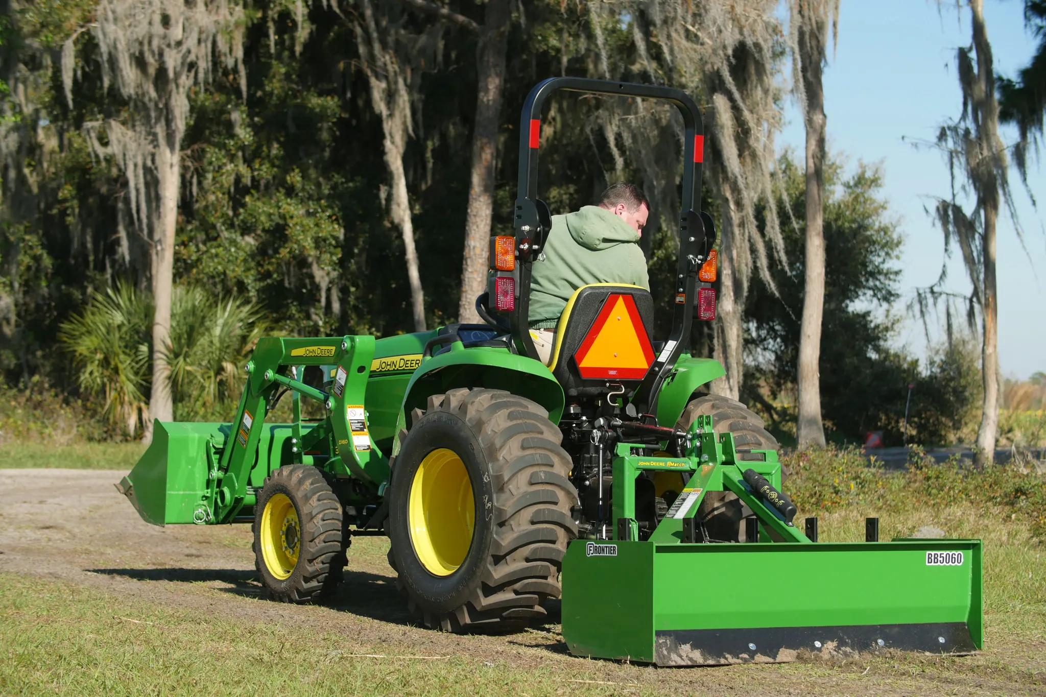 Rear left view of an operator using a Frontier BB50 Box Blade on a dirt track