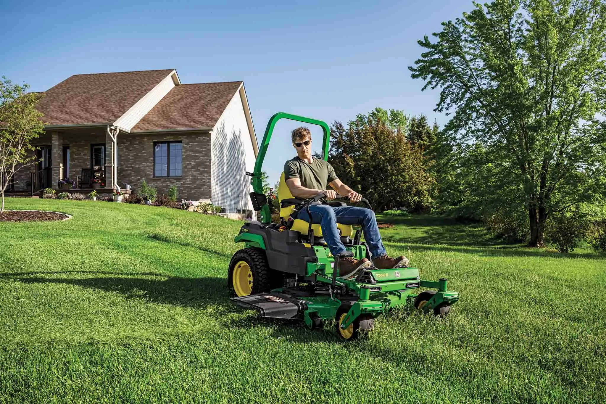 A Z560R zero-turn mower is used to mow the gentle sloped front lawn of a residence.