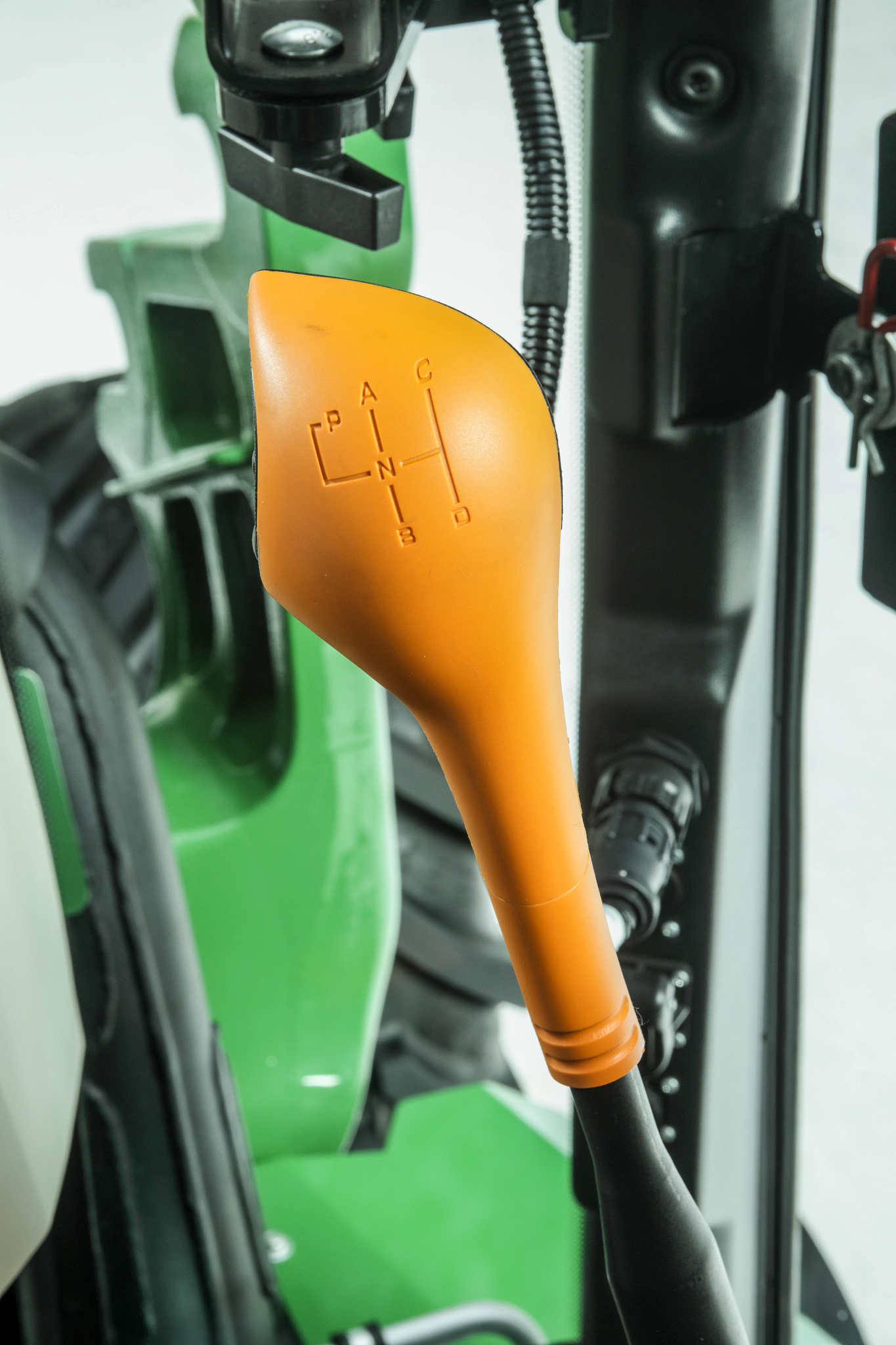 Close-up, studio view of a 5130ML tractor's orange gear lever in cab
