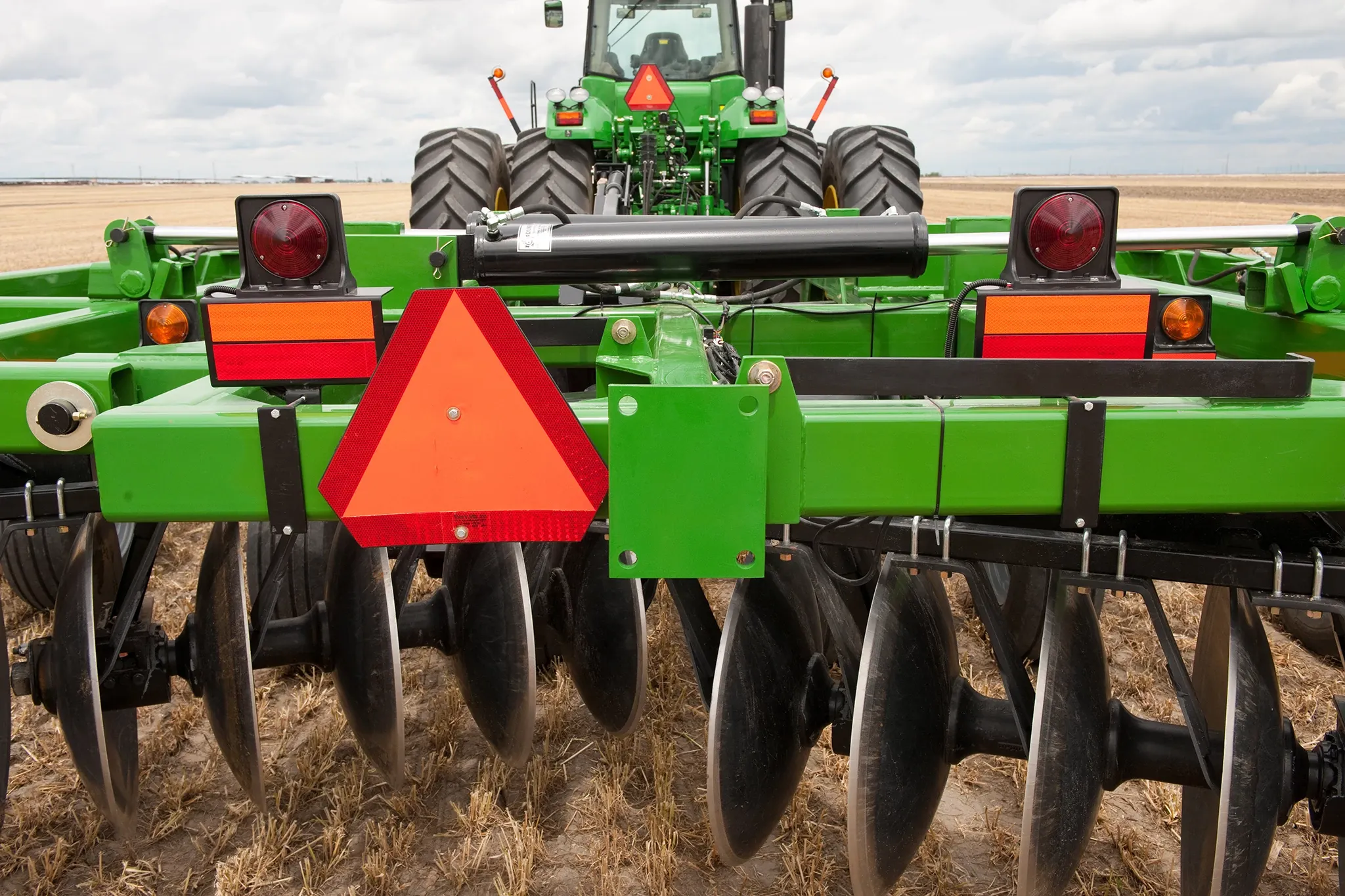 Close-up rear view of a tractor pulling a Frontier Tandem 51 Series Disk Harrow in the field