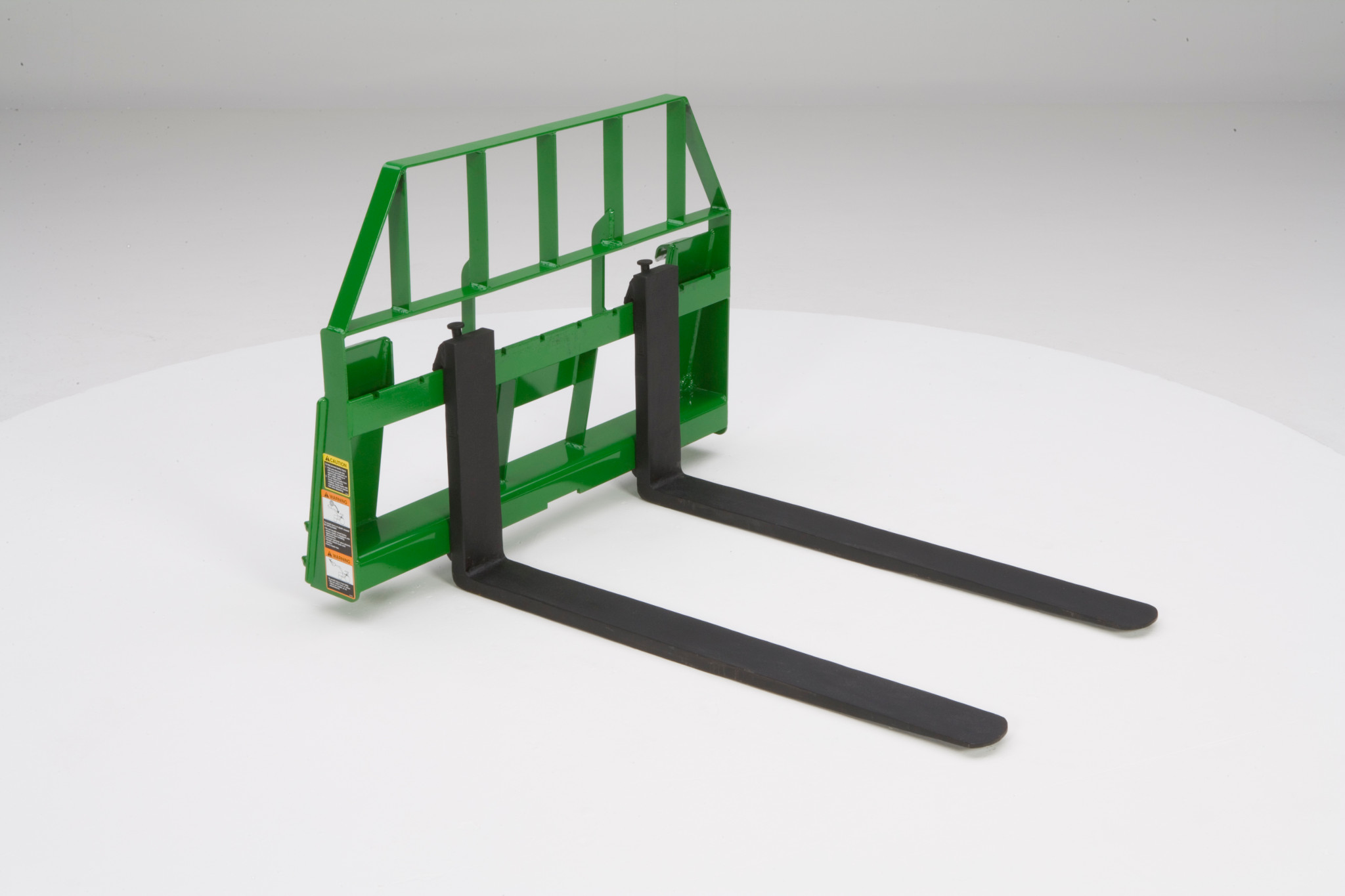 Green pallet fork attachment with two long black steel forks and a metal back frame on a white background