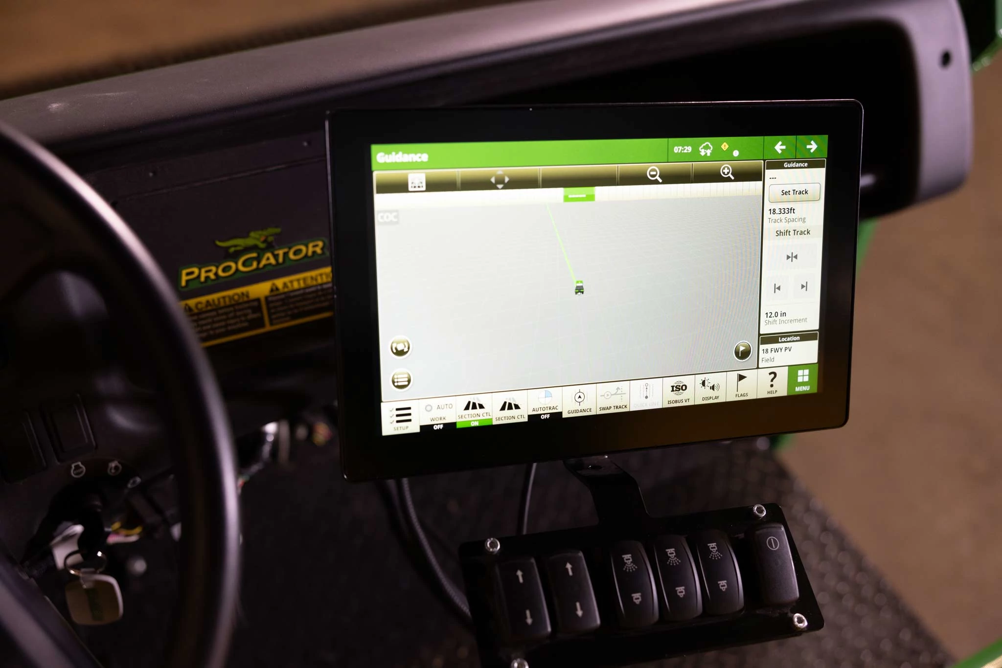 Close-up of the G5 Plus Universal Display with bright screen on the dash of a 2020A ProGator beside part of the steering wheel