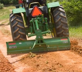 Front view of an RB21 rear blade grading a dirt road on the back of a tractor