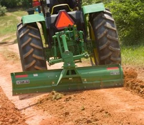 Front view of an RB21 rear blade grading a dirt road on the back of a tractor