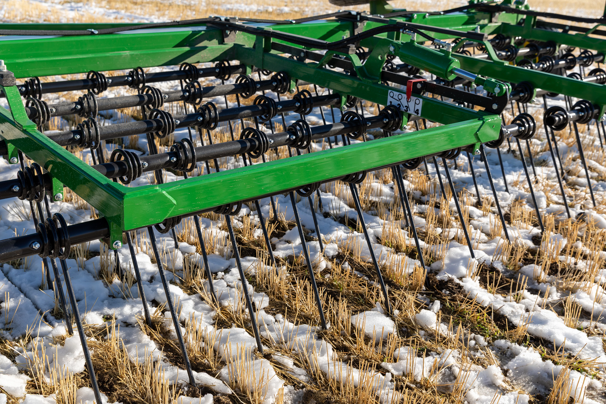 Front, angled view of an HH70 Heavy Harrow on a snow-dusted field
