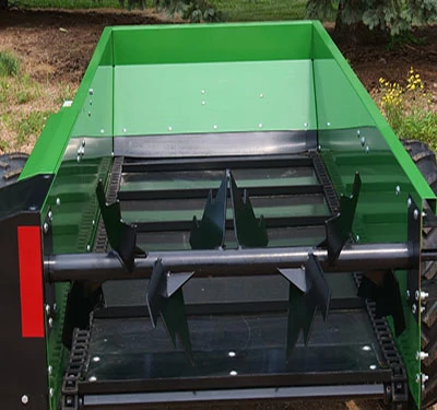 Top, rear view of an MS11 manure spreader and its poly-bonded floor beneath paddle beaters