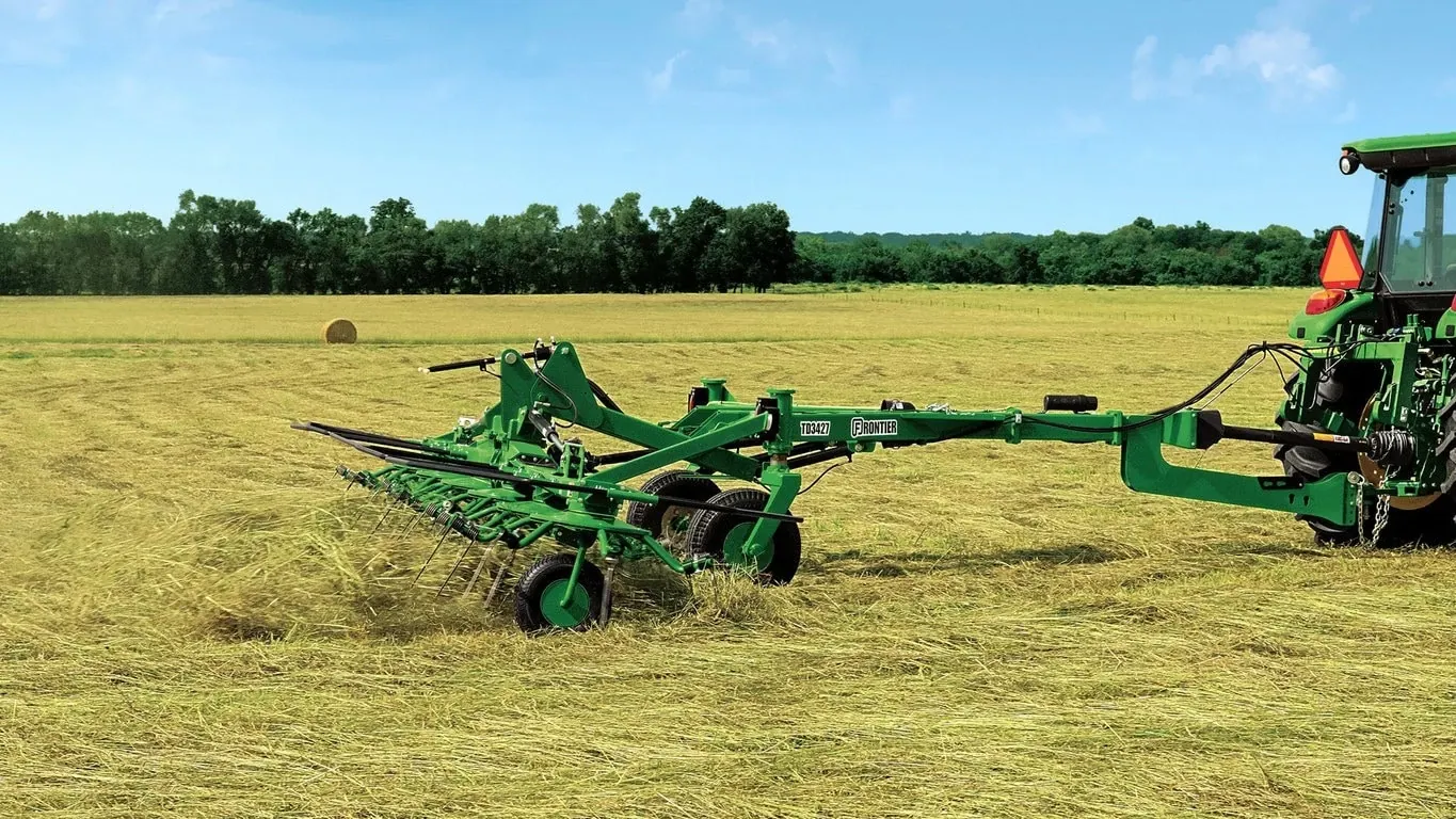 TD34 Hay Tedder pulled by tractor in the field