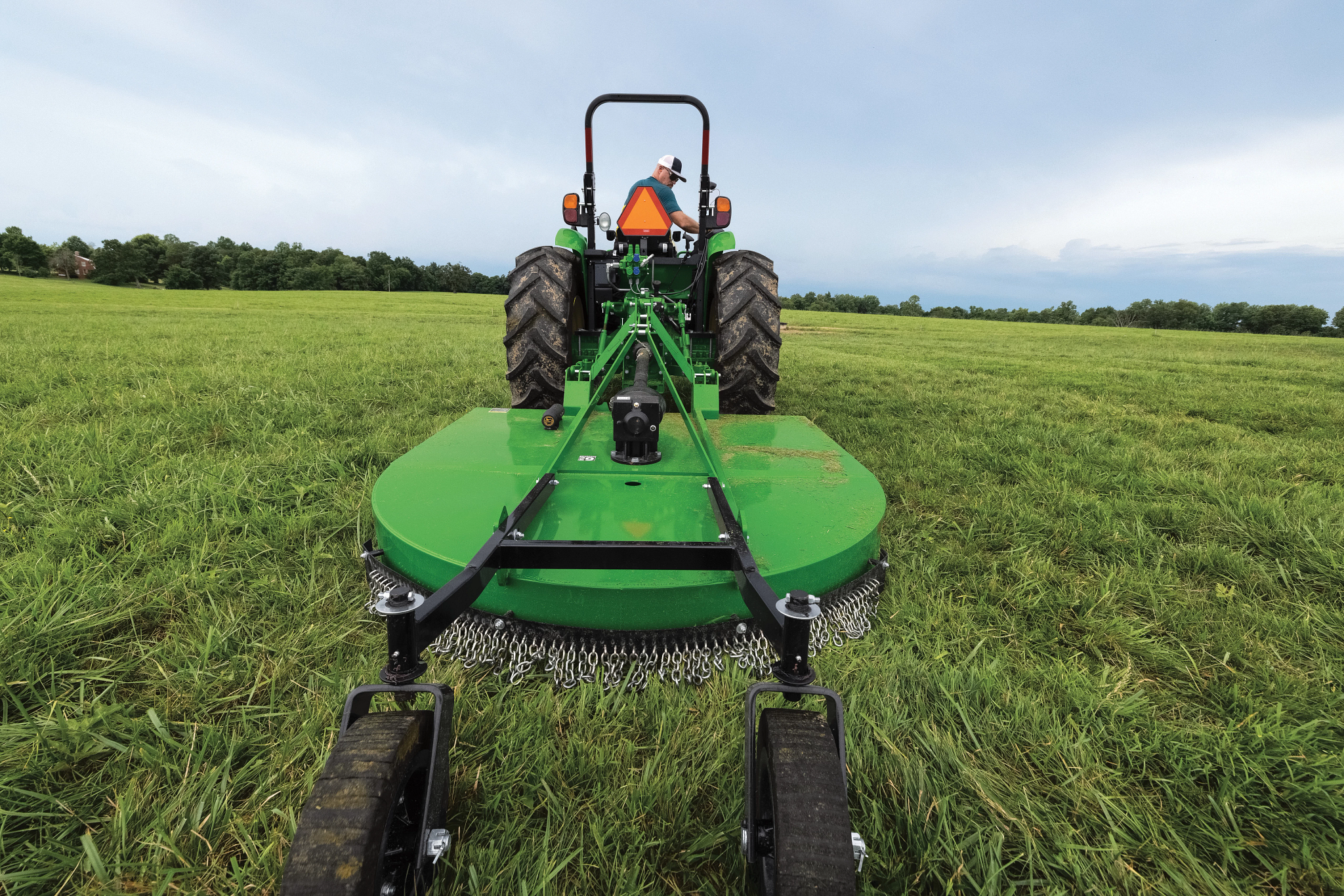 Rear field view of the RC2084 Rotary Cutter on 5 Series Tractor in a grassy field
