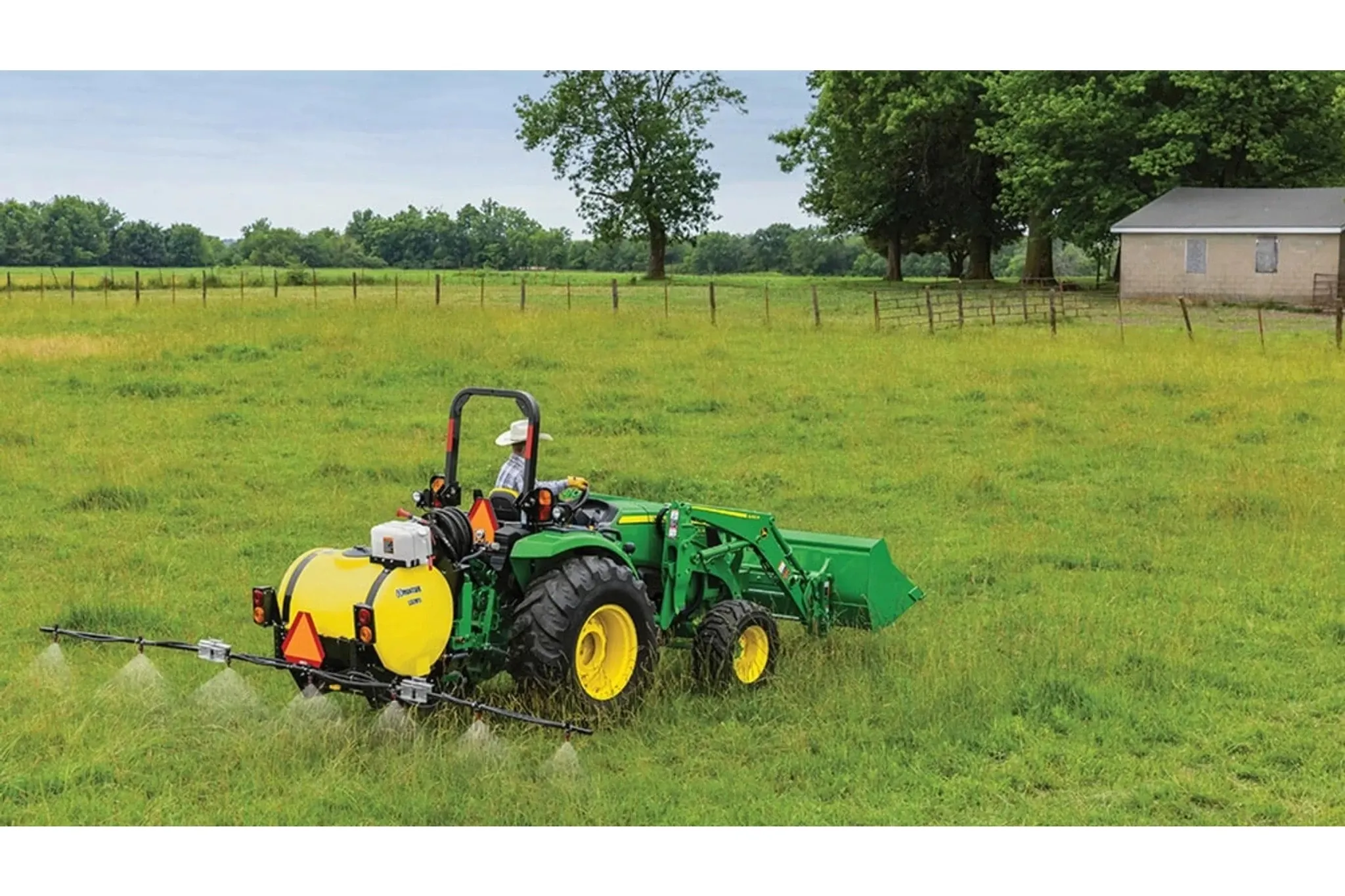4066M Heavy Duty Compact Tractors with a farmer is spraying a field with a sprayer