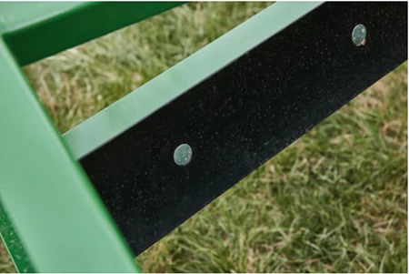 Top close-up of three green bars of a land plane's frame and black cutting edge