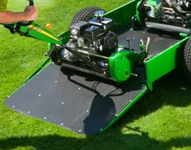 Front right view of an open 22B walk greens mower trailer with tailgate down, allowing a mower to be rolled aboard. The image showcases its black spray-on liner for bed and ramp.