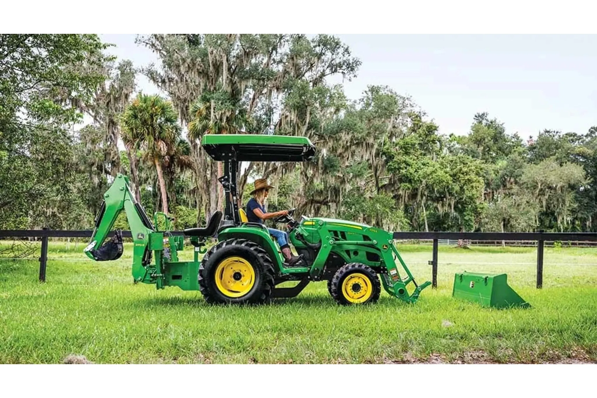 3025E 3 Series Compact Tractors with a farmer driving a tractor with a loader attached to it