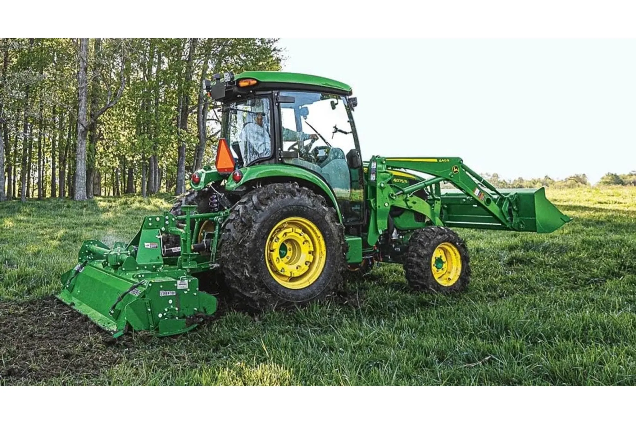 4075R Compact Tractor with a large front end loader in a field