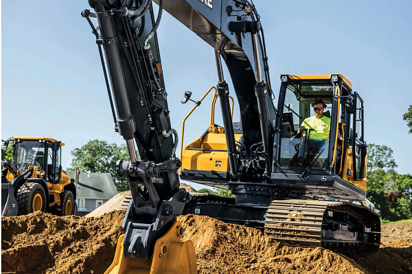 Front view of a 210 P-Tier Excavator scooping dirt on a job site