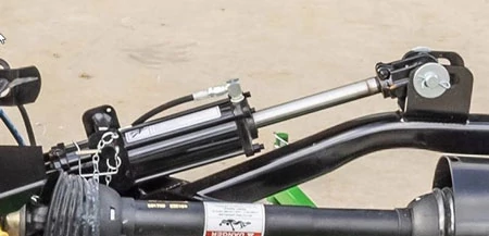 Close-up of a flex-wing grooming mower's wing deck hydraulic lift cylinder