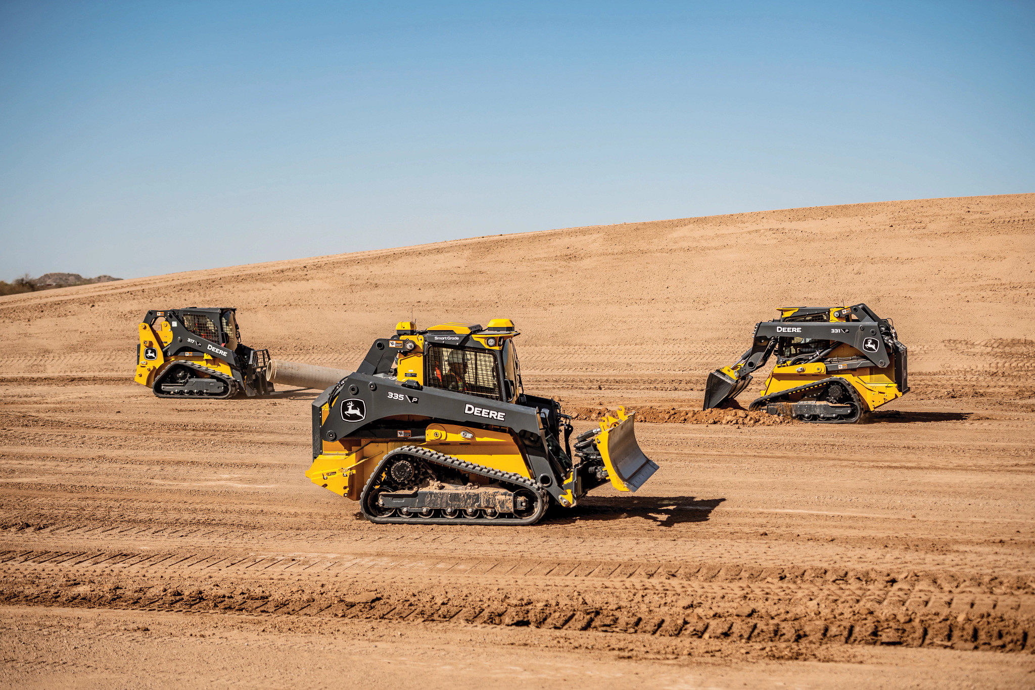 John Deere compact track loaders at work on a construction site