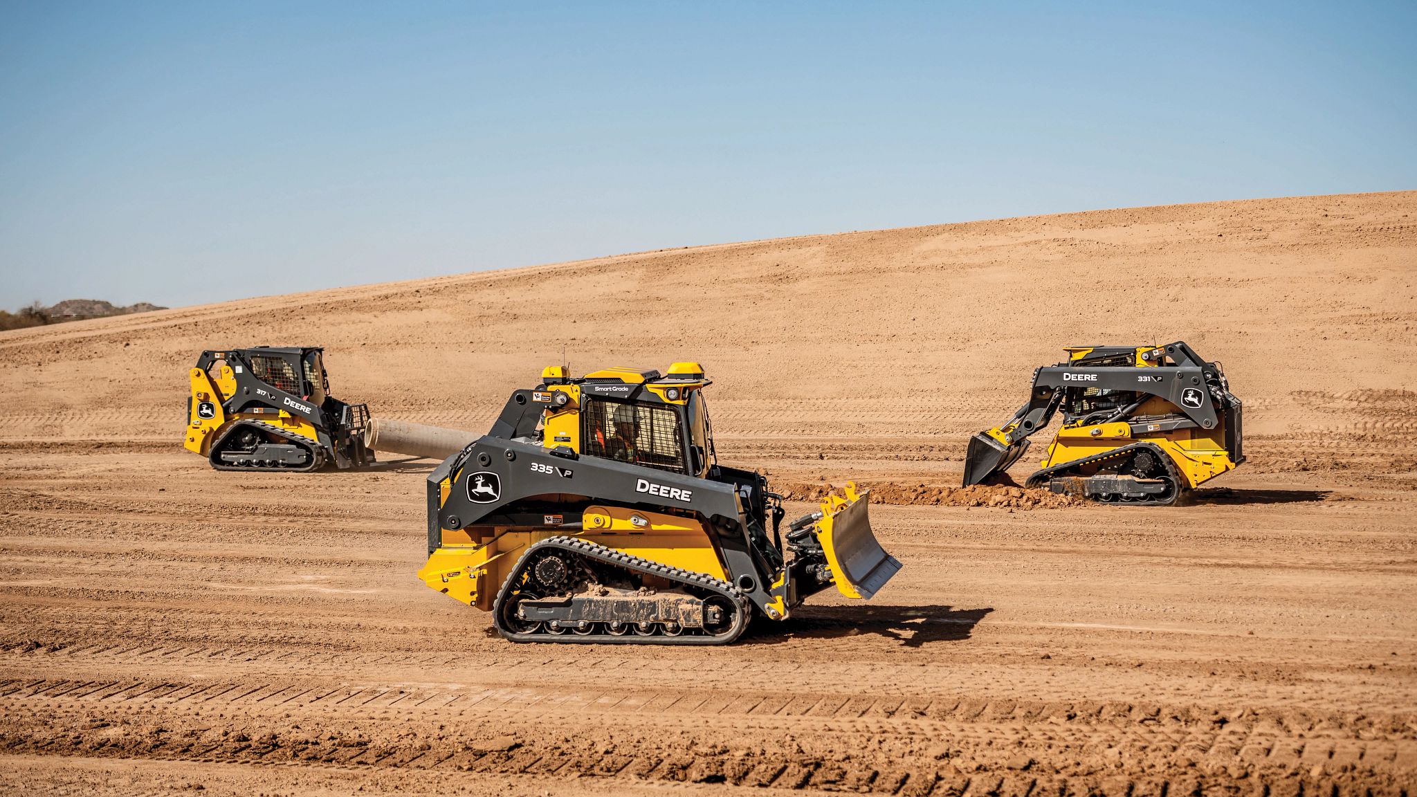 John Deere compact track loaders at work on a construction site