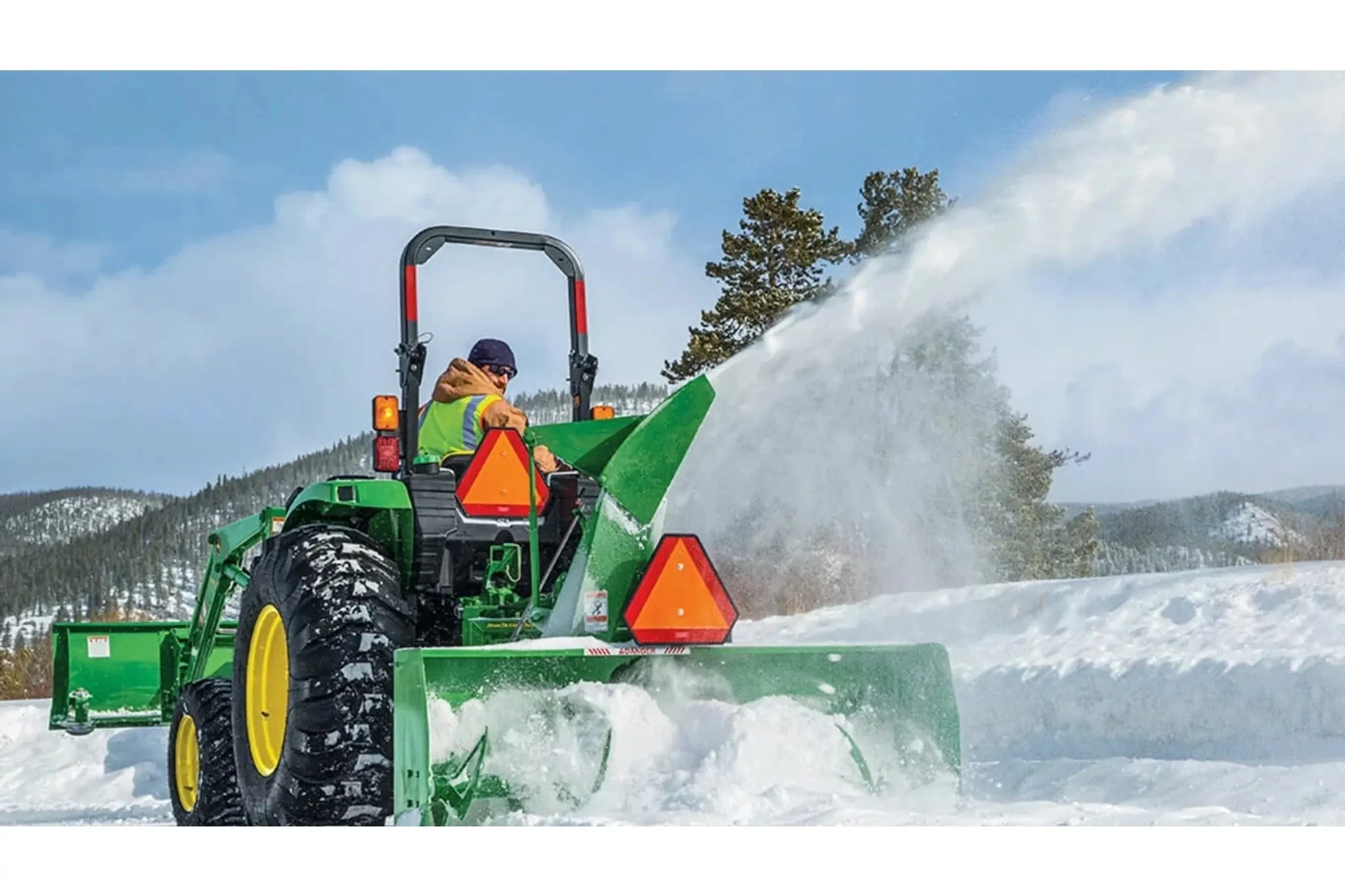 A person clearing snow using a 4052M Compact Tractor with a snow removal attachment