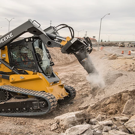 Side right view of an HH60C Hydraulic Hammer pummeling material at a roadside jobsite
