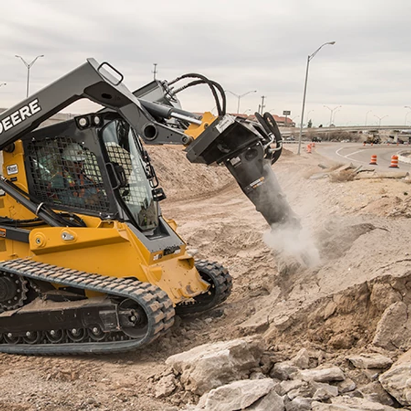 Side right view of an HH60C Hydraulic Hammer pummeling material at a roadside jobsite