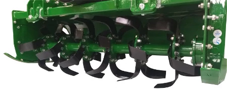 Studio close-up of the underside of a rotary tiller, showing the black tines and green housing