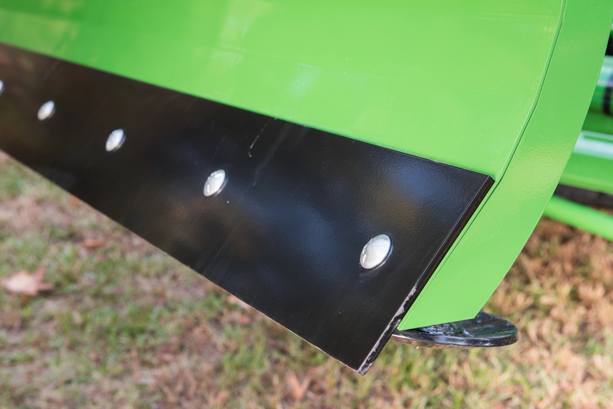 Front left close-up of the right edge of an AF10F front blade's reversible cutting edge