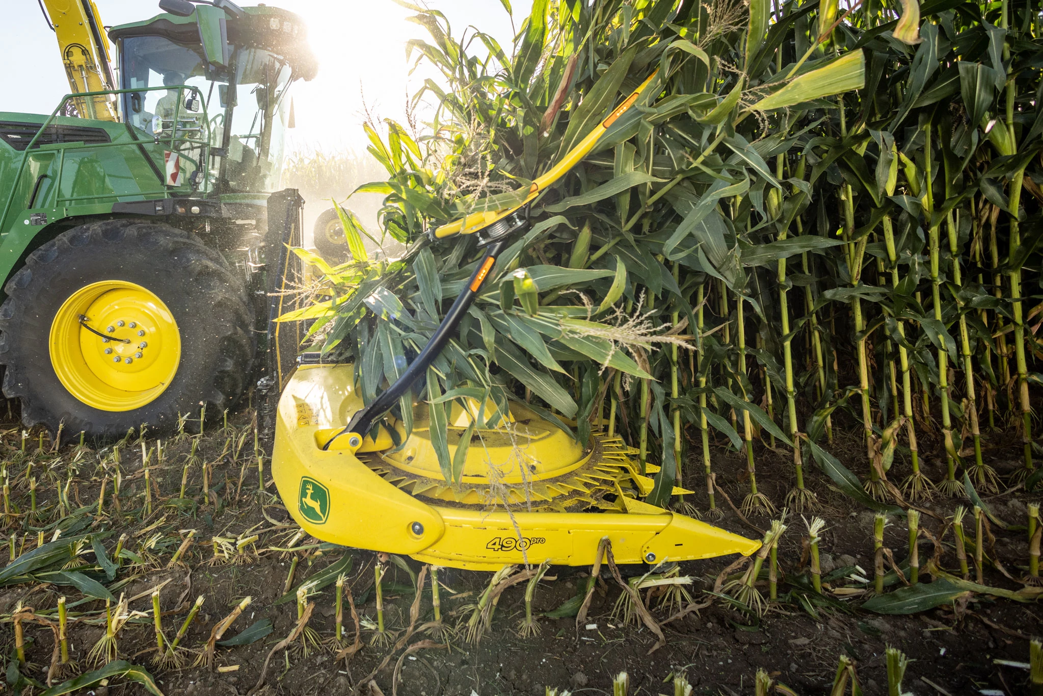 Side right view of a 490Pro Rotary Crop Header decimating fully-grown cornstalks in a field.