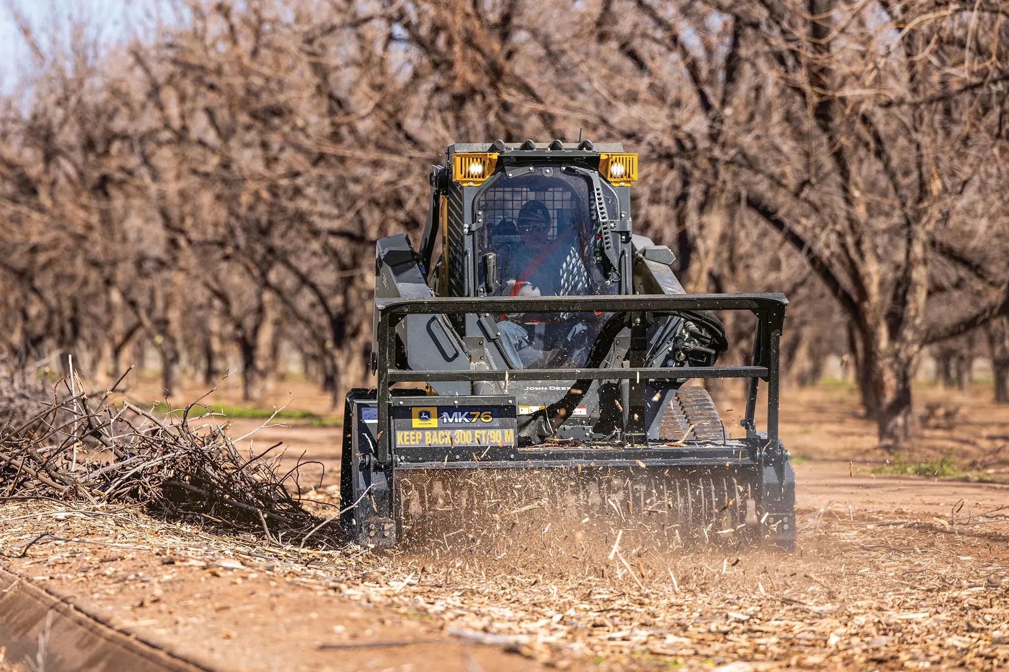 Front view of a 335 P-Tier compact track loader mulching brush with an MK76 mulching head