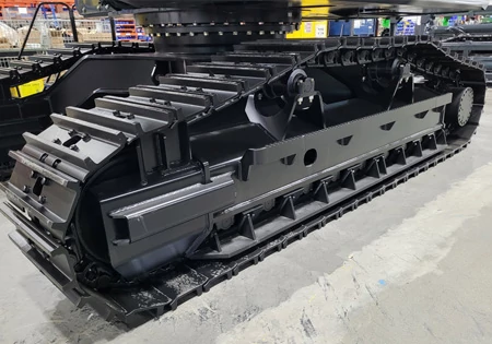 Side view of a swing machine's undercarriage, featuring one black track frame