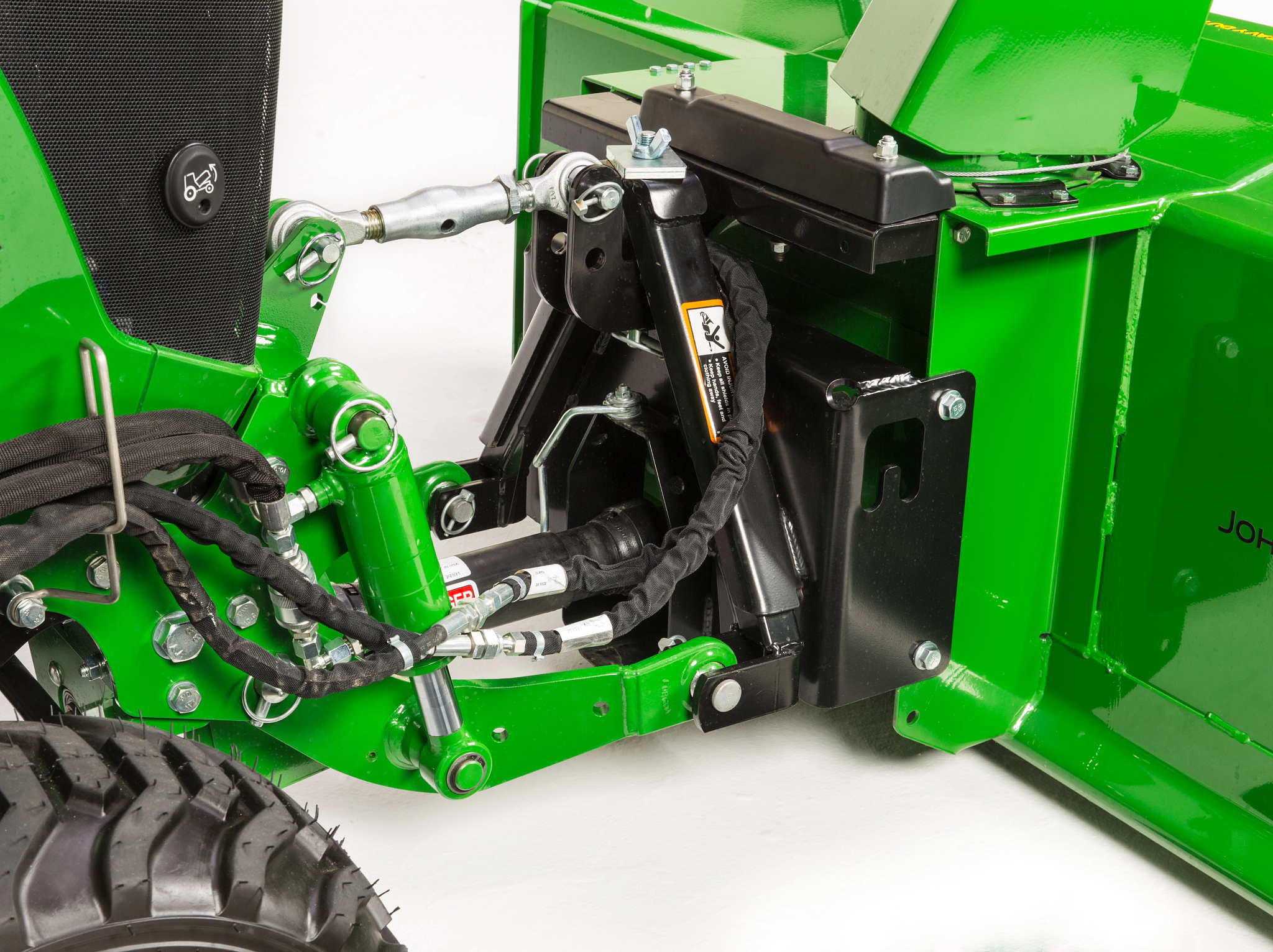 Side angled studio view of a 54 Inch Heavy Duty Snow Blower attaching to a 1025R tractor via front 3-Point Hitch
