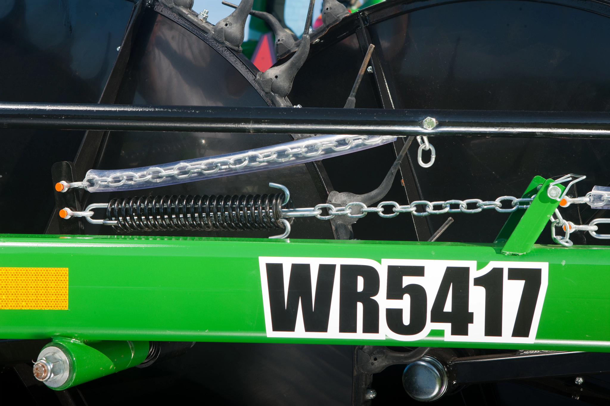 Close-up, side view of a WR5417 Wheel Rake's dampening springs and two rake wheels behind