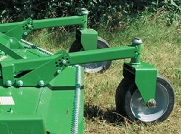 Side view of two grooming mower caster wheels connected to the mower via rail supports resting on the grass