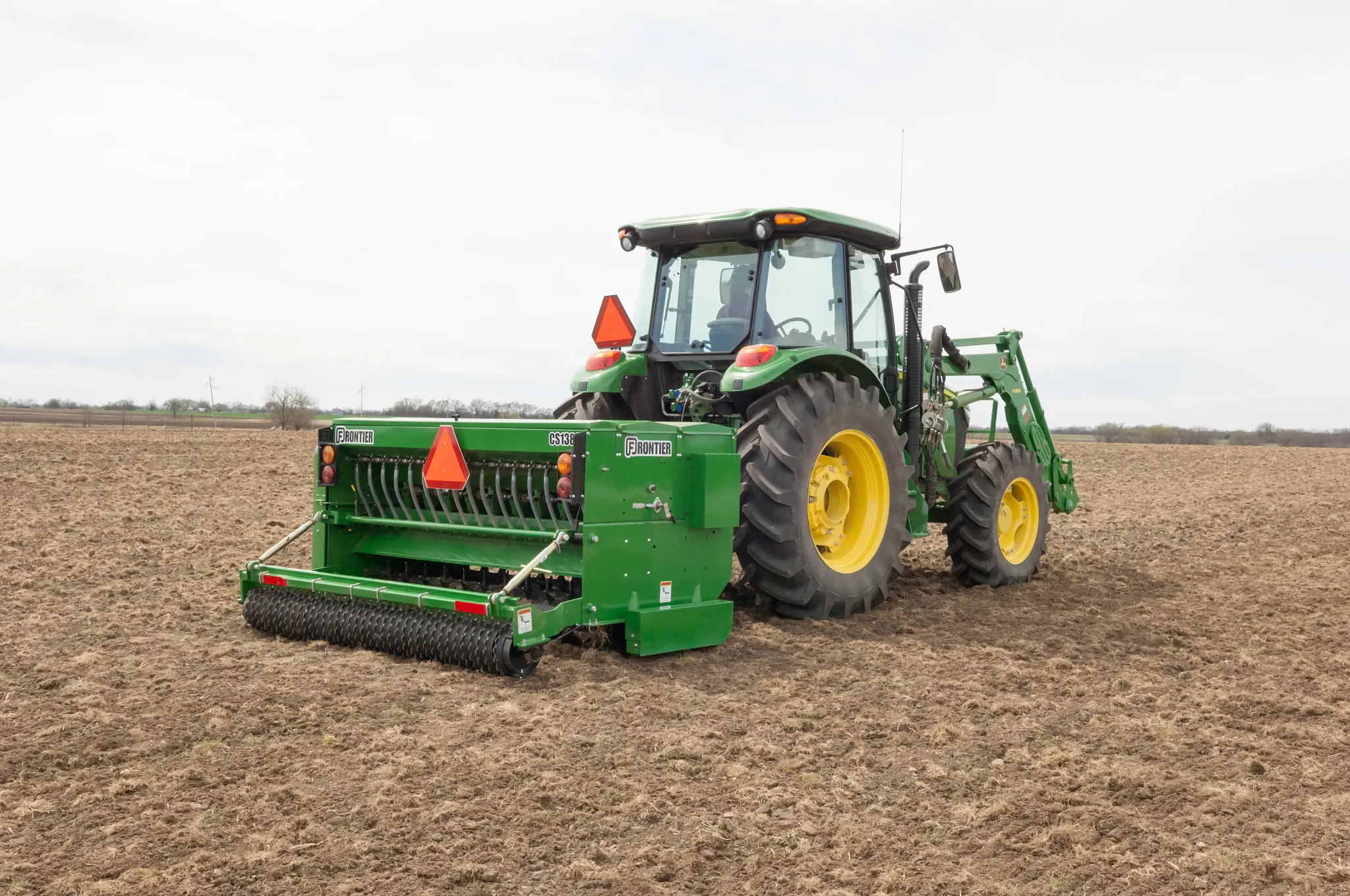 Frontier CS1384 Conservation Seeder being pulled by a tractor in a field