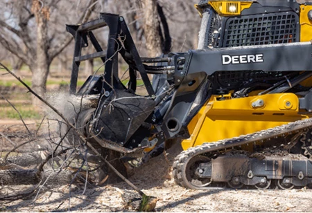 Close-up of an MK76 Mulching Head decimating a tree stump on the front of a 335 P-Tier compact track loader