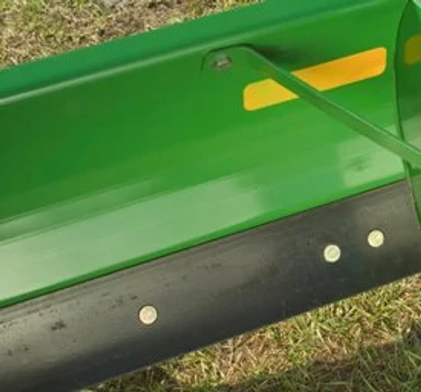 Close-up of a rear blade's black reversible cutting edge on green blade