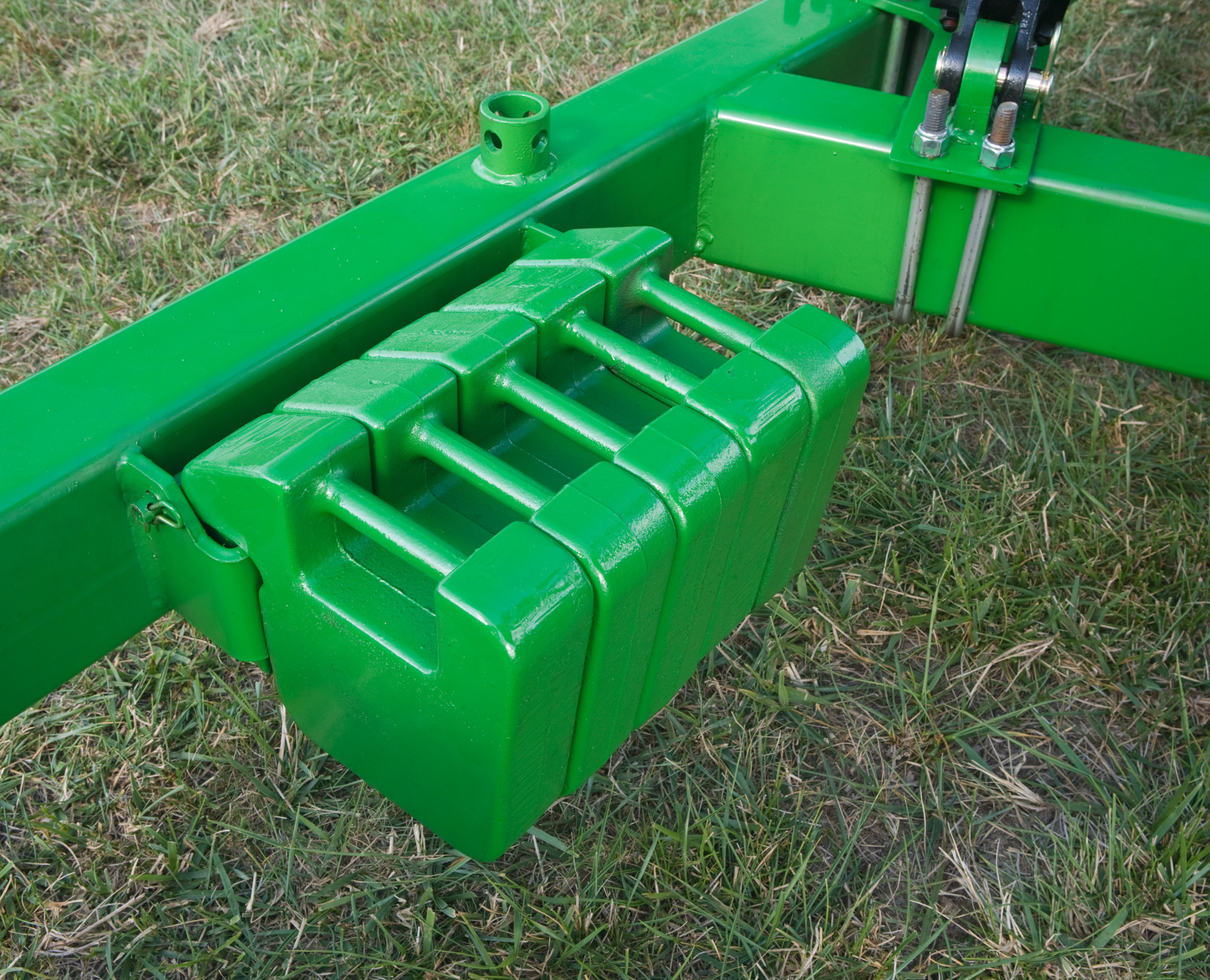 Five weights attached to a bar on the DC Disc Mower Caddy