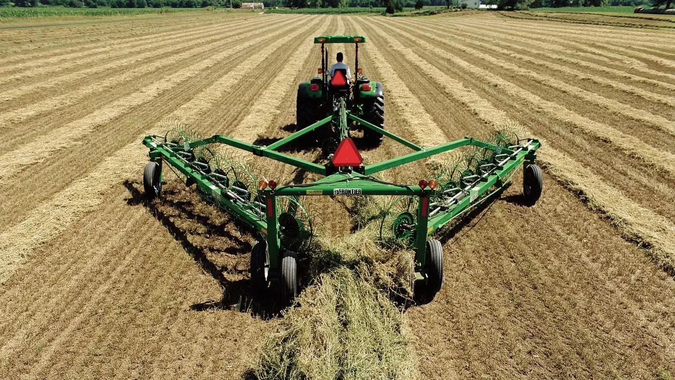 Farmer raking hay with a WR12 Wheel Rake
