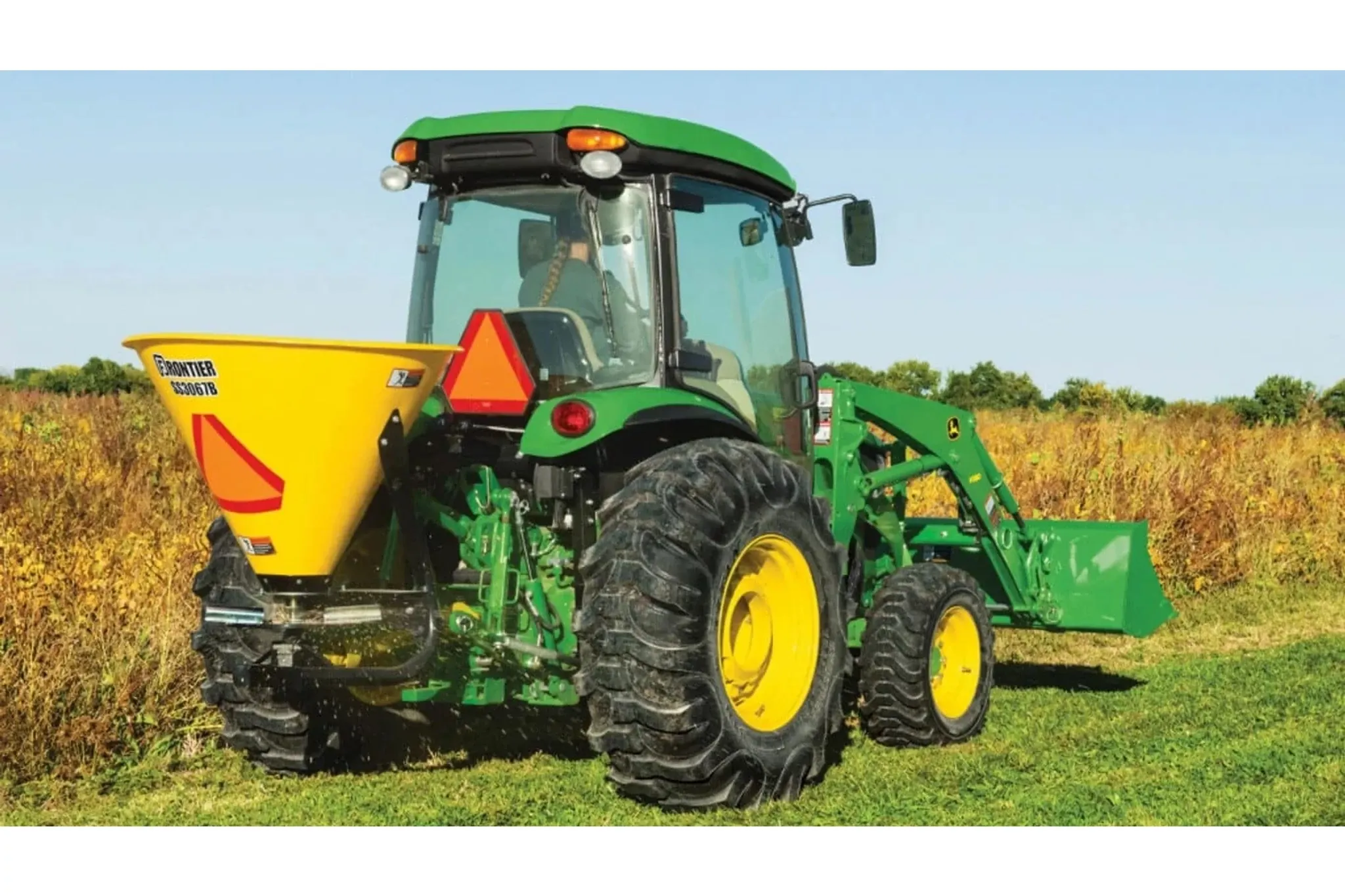 4066R Compact Tractor with a close up of a tractor with a spreader on a field