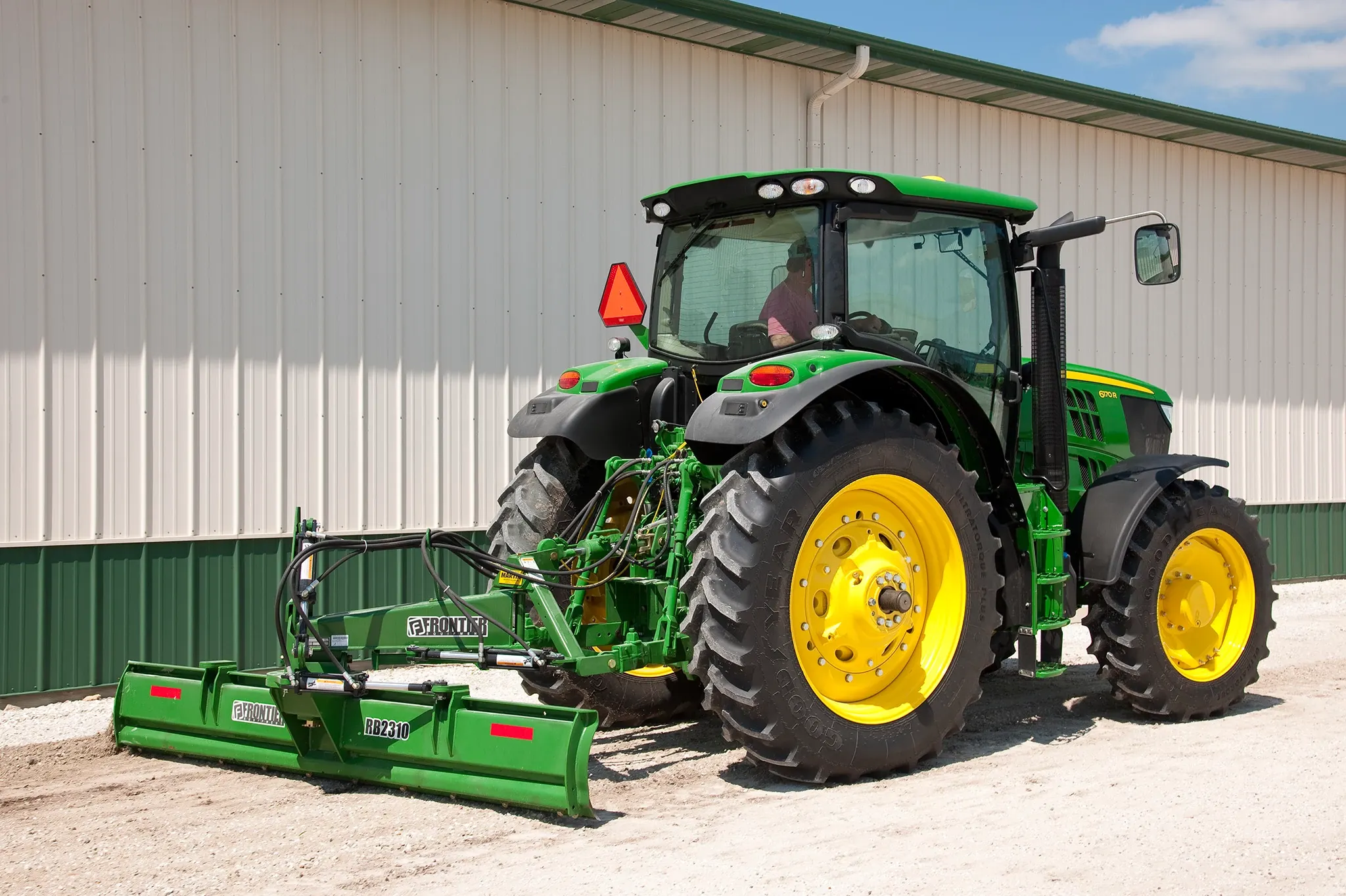Field view of 6170R Tractor with RB2310 Rear Blade next to a shed