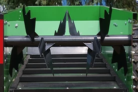 Front view of an MS11 manure spreader's black paddle beaters within the open, green container