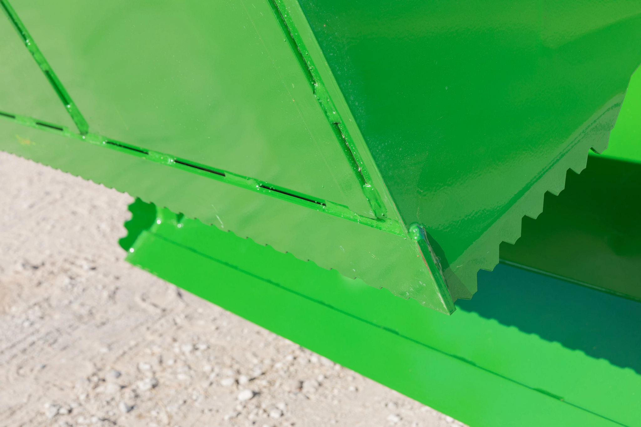 Close-up corner view of an AY11F 4-in-1 bucket's serrated edge