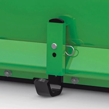 Close‑up of a green equipment attachment bracket showing a vertical mounting tab with a spring‑clip pin and black hook beneath.